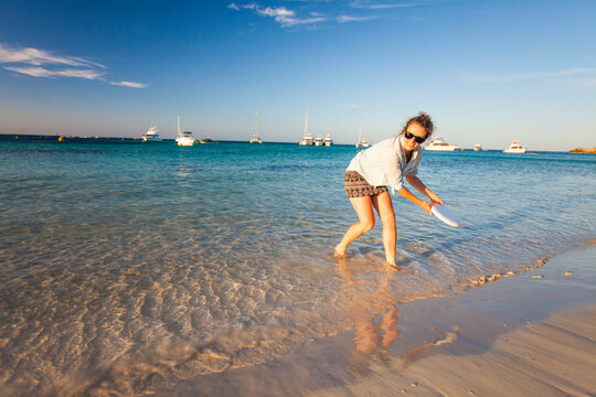 Woman throwing plastic disc on beach,&Acirc;&nbsp;Rottnest&Acirc;&nbsp;Island, Perth, Western Australia, Australia