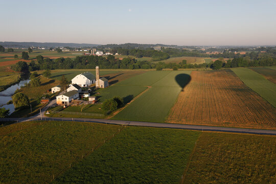 Shadow of hot air balloon flying over farm, Lancaster County, Pennsylvania, USA