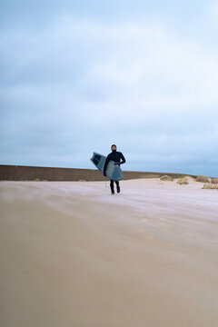 surfing in Kamchatka. Man in a wetsuit with a surfboard on the s
