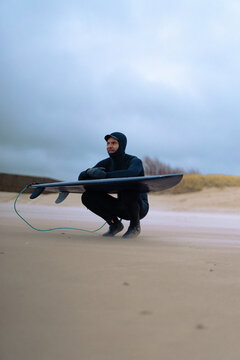 surfing in Kamchatka. Man in a wetsuit with a surfboard on the s