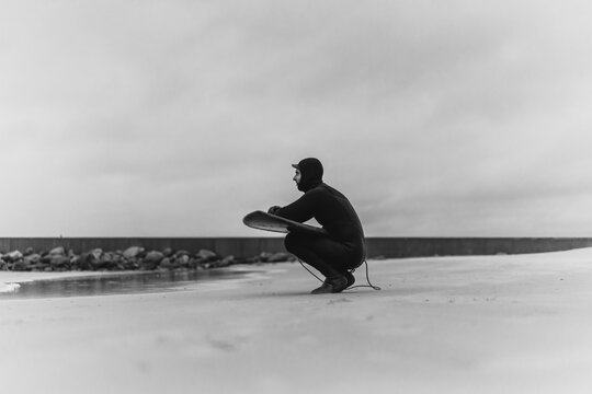 surfing in Kamchatka. Man in a wetsuit with a surfboard on the s