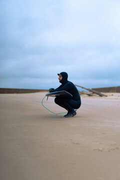 surfing in Kamchatka. Man in a wetsuit with a surfboard on the s