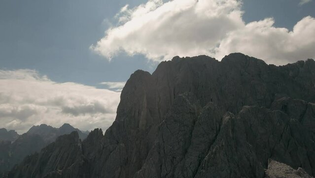 Action camera footage from FPV racing drone flying in clouds above mountain range in Austria in the summer. Spectacular views of tmountains in the background. Drone is diving. LuPa Creative.