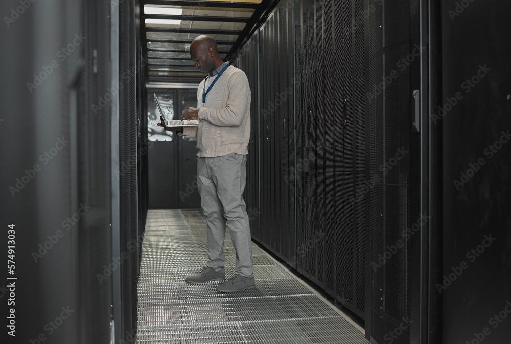 Poster Server room, data center or IT black man with laptop for research, engineer working in dark server room. Computer, cybersecurity and analytics with male programmer problem solving or troubleshooting