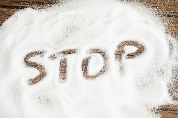 STOP, sweet granulated sugar with text, diabetes prevention, diet and weight loss for good health.