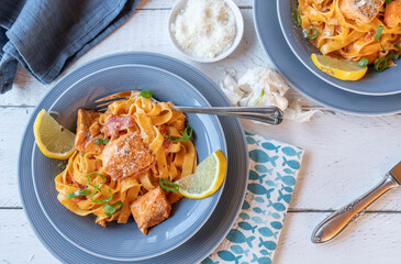 Pasta with salmon and creamy tomato sauce on plates