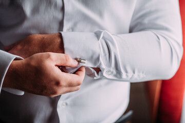 A large photo of mens hands buttoning cufflinks on shirt sleeves 4438.
