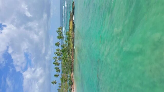 Drone vertical shot of  Playa Los Coquitos with clear water and palm trees during sunny day