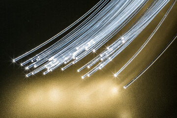 Bundle of optical fibers with lights in the ends. Yellow background.