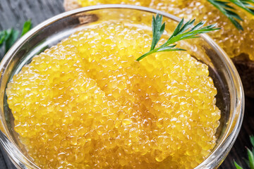 Pike caviar or roe in the bowl on wooden background.