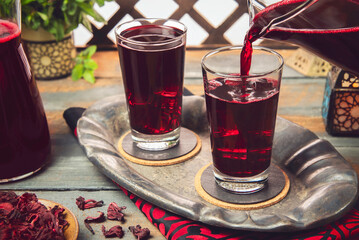Arabic Cuisine; Middle Eastern popular hibiscus drink or (Karkadeh). It is traditional Arabic drink served during the holy month of Ramadan. It is a sweet infusion made from hibiscus flower. - obrazy, fototapety, plakaty