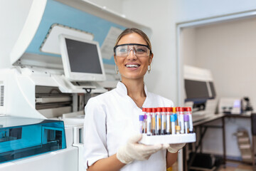 Blood test tubes. Female scientist examining blood test tubes at her laboratory dna testing...