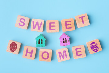 Toy houses and wooden blocks with words Sweet Home and Easter eggs icons. Easter holidays concept