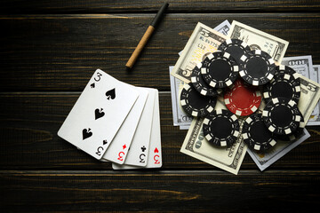 A poker game with a winning combination of four of a kind or quads. Cards with chips and money on a black table in a poker club