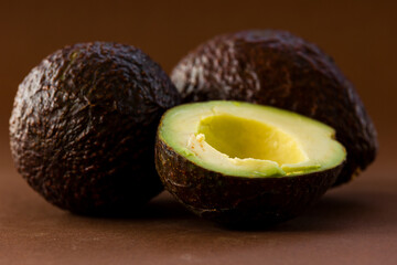 close up fresh avocados on brown background