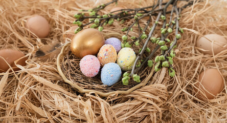 Fototapeta na wymiar Colorful Easter eggs in the nest rotate. Greeting card with quail eggs and chicken eggs. Happy Easter holiday. Christian celebration, family traditions, flat lay top view