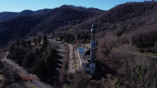 Aerial View Of The Minaret At Abandoned Ghost Town Consonno. Slow Ascending Shot Dolly