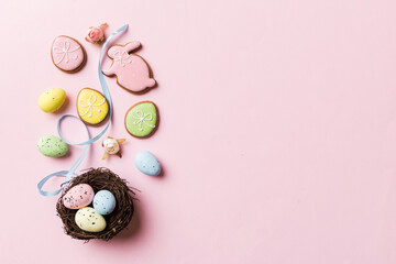 Colorful easter eggs in nest on table background with copy space top view