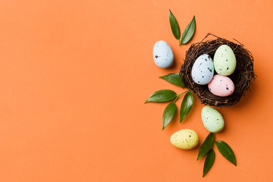 Colorful easter eggs in nest on table background with copy space top view