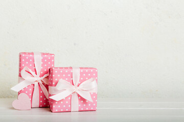 gift box with red bow and red heart on colored background. Perspective view. Flat lay