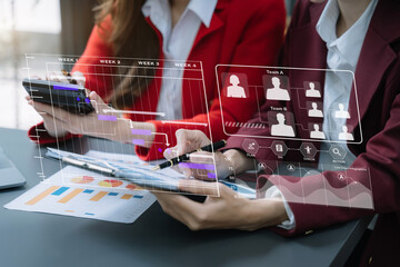 Businessman team hand Project manager working and update tasks and Gantt chart scheduling virtual diagram.with smart phone, tablet and laptop in office.