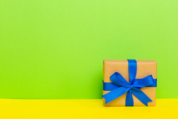 holiday handmade paper present tied blue ribbon bow top view with copy space. Flat lay holiday background. Birthday or christmas present. Christmas gift box concept with copy space