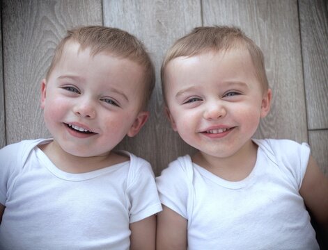 Overhead portrait of smiling twin brothers lying on the floor