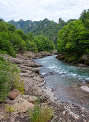 Summer, river, mountainous terrain, tourist routes running through the park, a place for walking and recreation.