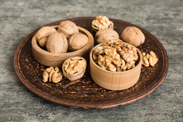 Fresh healthy walnuts in bowl on colored table background. Top view Healthy eating bertholletia concept. Super foods