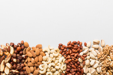 different nuts frame background. Close up, top view, flat lay with vopy space. Walnut, pistachios, almonds, hazelnuts and cashews