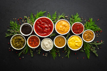 Different types of sauces in bowls with seasonings, rosemary and dill, thyme and and peppercorns,...
