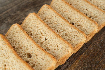 Slices of toast bread on wooden plate. Traditional bread for breakfast