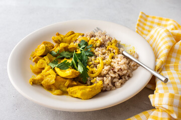 Healthy lunches, brown rice with chicken with turmeric and curry seasoning and fresh herbs