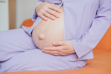 Pregnant woman keeps her hands on her belly
