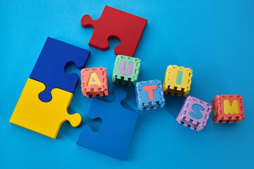 Word Autism on puzzle cubes on blue background. Autism awareness