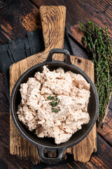 Cod liver Spread with oil in a skillet. Wooden background. Top view