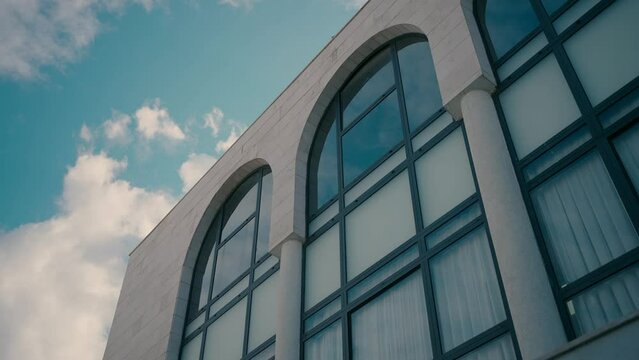 Windows of a synagogue from the outside with clouds in the sky in the background