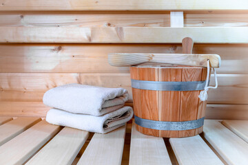 Fototapeta na wymiar Detail from bucket and white towels in a sauna, wellness accessories