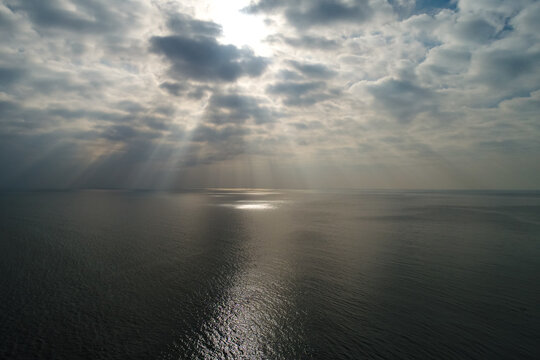 Sun Rays Bursting Through Cumulus Clouds Over The Sea. Aerial Sea Landscape In A Spectacular Cloudy Day.