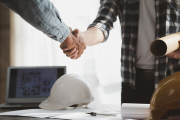 Team engineers and architects shake hands with the condo project owners after the meeting to present room plans and details of the condo building structure. Concept of building design and construction