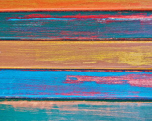 Wooden boards painted with a variety of bright colors. Bluish, yellow and orange horizontal pattern.