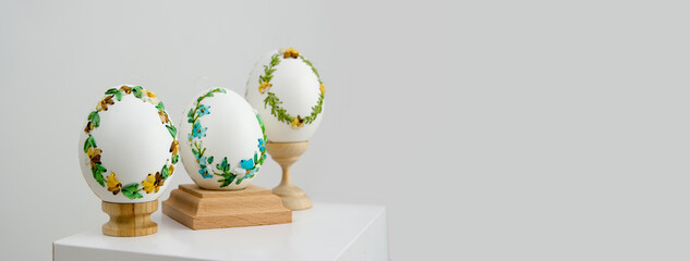 lavender background postcard baner calendar empty space holiday easter eggs embroidery ribbons on eggshell krashanka three eggs on special wooden stands on a white background