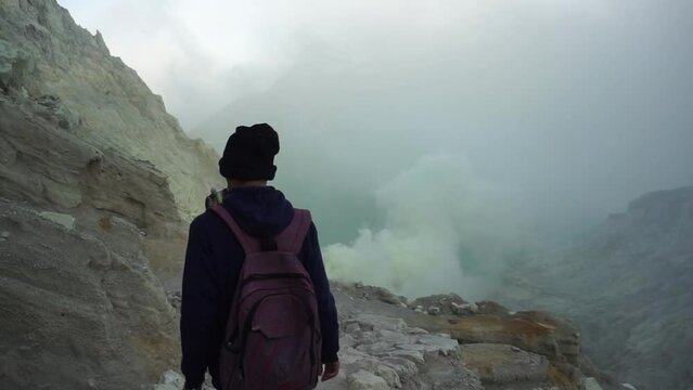 Tourist walking around the crater of mount Ijen.