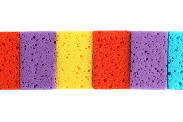 Bright multi-colored sponges in a stack lie on a white background.	
