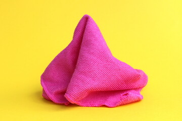 A pink rag for cleaning lies on a yellow background