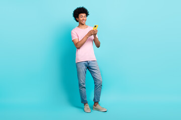 Full body photo of positive blogger young man hold smartphone order new clothes ebay shopping season day isolated on aquamarine color background