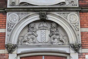 Sculpted Lions Holding the Amsterdam Coat of Arms on a Historic Building Facade in Amsterdam, Netherlands