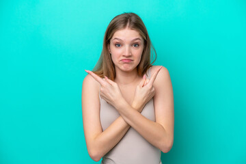 Teenager Russian girl isolated on blue background pointing to the laterals having doubts