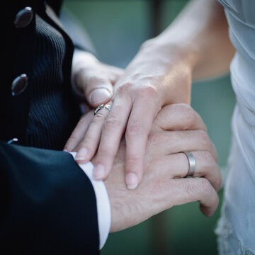Crop married couple holding hands