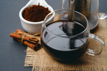 Black coffee and cinnamon sticks. Aromatic coffee from freshly ground coffee grounds.